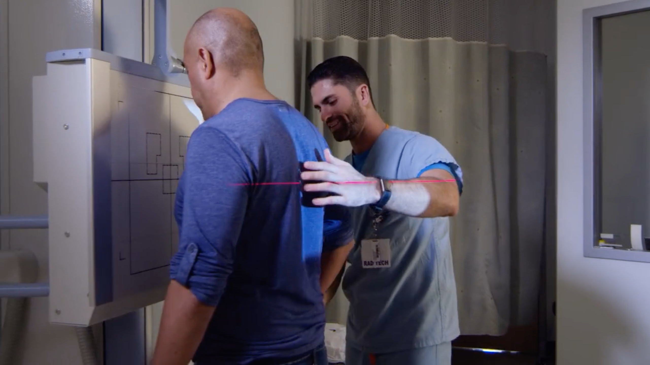 A technician assists a patient with a digital radiography.