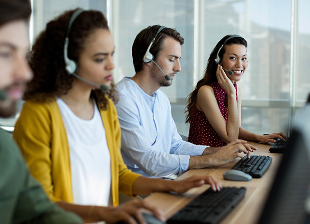 Customer Support 4 People with Headsets on Computers