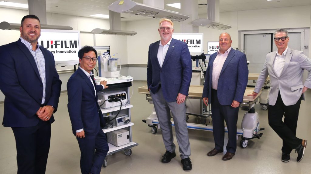 ASGE and Fujifilm leadership in front of medical equipment